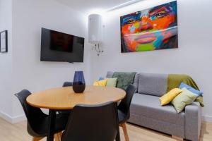 a living room with a table and a couch at Apartamentos TriBeca Centro II in Albacete