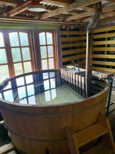 um barril de vinho de madeira num quarto com janelas em Butamacho Cabaña con Tinaja x Día em Chonchi