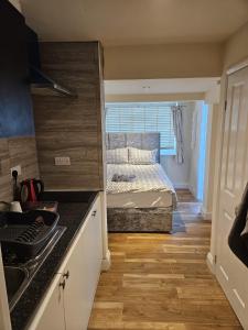 ein kleines Schlafzimmer mit einem Bett und einer Küche in der Unterkunft Entire en-suite flat in Windsor home with free parking in Windsor