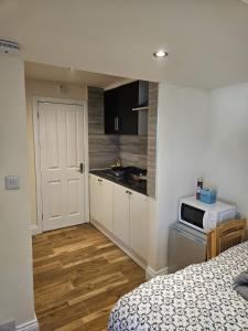 a room with a kitchen with a bed and a microwave at Entire en-suite flat in Windsor home with free parking in Windsor