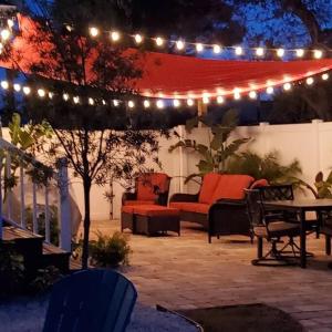 a patio with a table and chairs and lights at Waterfront home with private dock, walk to beach in Saint Augustine