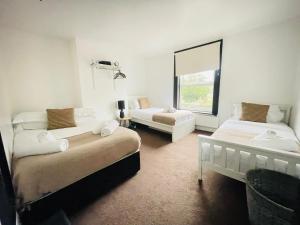 a white room with two beds and a couch at Lovely Dog Friendly, 3 Bed Home Sleeps 8, with Parking & Fenced Garden WORK CONTRACTOR LEISURE, JASPER in Cambridge