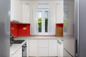 a kitchen with white cabinets and a window at Luxury villa Vincent in Slatine
