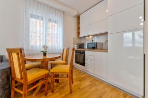 Una cocina con una pequeña mesa y sillas en una cocina. en Tijana, en Zlatibor