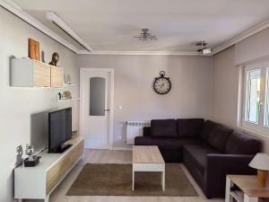 a living room with a couch and a tv at la casa de la avioneta in Piedrahita