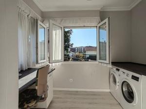 a laundry room with a washing machine and a window at la casa de la avioneta in Piedrahita