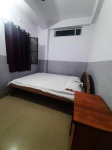 a small bedroom with a bed and a table at SPOT ON Gajadhar Rest House in Deoghar
