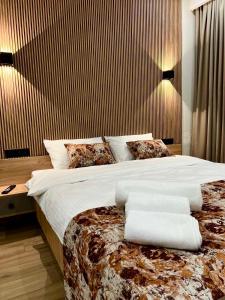 a bedroom with a large bed with white sheets and pillows at Gudauri Twins 404 in Kʼumlistsʼikhe