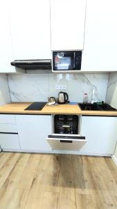 eine Küche mit einer Arbeitsplatte und einer Mikrowelle in der Unterkunft Евродвушка Тандау in Taldykolʼ