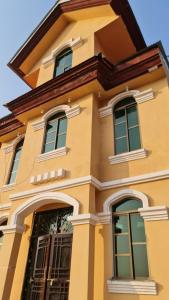 a yellow building with windows and a roof at Patriata Luxury Suits in Murree