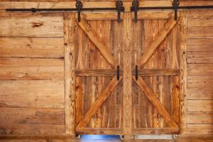 uma porta de garagem de madeira numa parede de madeira em Na Chałupki 