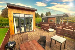 a house with a deck with a table and chairs at Little Eden Country Park, Bridlington with Private Hot Tubs in Bridlington +124 photos