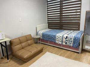 1 dormitorio pequeño con 1 cama y 1 sofá en Stay SonSu, en Jeju