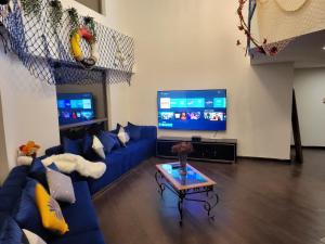a living room with a blue couch and a tv at Atlantis View Hostel in Dubai