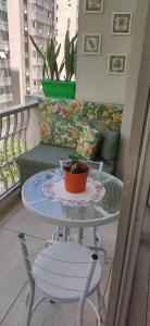 une table avec une plante en pot sur un balcon dans l'établissement Apto PITANGUEIRAS SACADA-5Min Praia 1 vaga SERV PRAIA, à Guarujá