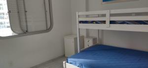 une chambre avec un lit superposé et un miroir dans l'établissement Apto PITANGUEIRAS SACADA-5Min Praia 1 vaga SERV PRAIA, à Guarujá