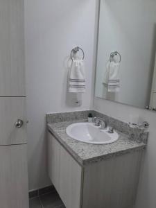 a bathroom with a sink and a mirror at Aqualina orange Girardot in Girardot