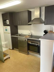 a kitchen with a sink and a stove top oven at Lakeview Residence 'Casa Naranjas' Mar Menor Golf and Leisure Resort in Torre-Pacheco