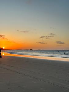 une personne se promenant sur la plage au coucher du soleil dans l'établissement Apartamento Flecheiras, à Trairi