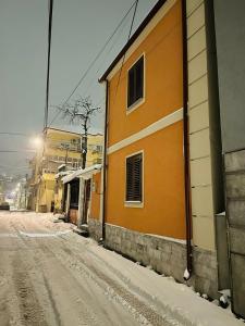 um edifício laranja numa rua coberta de neve em Vila Alba em Korçë
