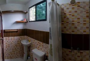 a bathroom with a toilet and a sink and a shower at Casa Mañana in Puerto López