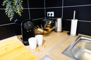 a kitchen counter with a coffee maker and cups on it at Paris I 77m Cosy luxe I Near by subway 11 & airport in Bagnolet +70 photos