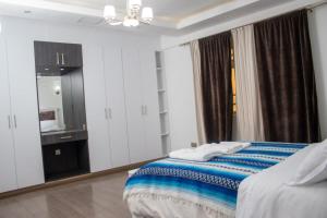 Habitación blanca con cama y espejo en 4bedroom Navilla westlands Nairobi, en Nairobi