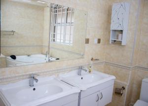 Baño con 2 lavabos y espejo en 4bedroom Navilla westlands Nairobi, en Nairobi