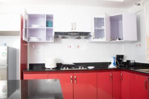 cocina con armarios rojos y encimera negra en 4bedroom Navilla westlands Nairobi, en Nairobi