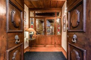 a hallway with wooden walls and a door with a lamp at Albergo Falterona in Stia