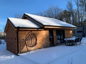 a small building with a table in the snow at Chalet Liquidambar in Zutendaal