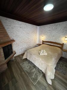 - une chambre avec un lit, des serviettes et une cheminée dans l'établissement Chalé Recanto Luar, à Monte Verde