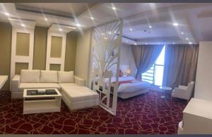 a bedroom with a couch and a bed in a room at Sokon Ladn Hotel in Riyadh