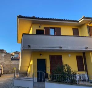 une maison jaune avec volets bruns dans une rue dans l'établissement al 4e, à Montopoli in Val dʼArno