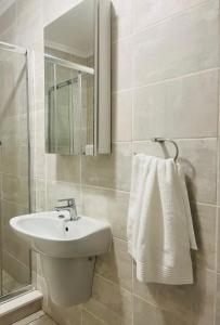 bagno bianco con lavandino e specchio di Lethabo Eco_Estate a Boksburg