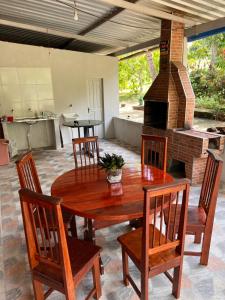 a wooden table and chairs in a kitchen with a fireplace at Casa Encanto in Manacapuru