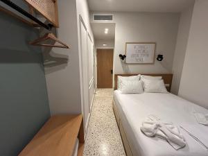 a small bedroom with a bed with white sheets at Belle Athenes - Luxury Rooms at Monastiraki Railway Station in Athens