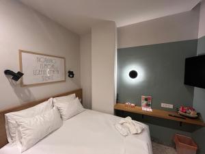 a bedroom with a bed and a flat screen tv at Belle Athenes - Luxury Rooms at Monastiraki Railway Station in Athens