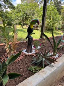 uma estátua de um pássaro num toco num jardim em Casa Encanto em Manacapuru
