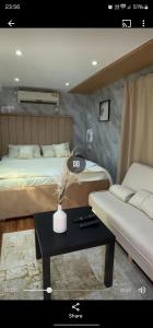 a bedroom with two beds and a table with a couch at Hatta Farm caravan in Hatta