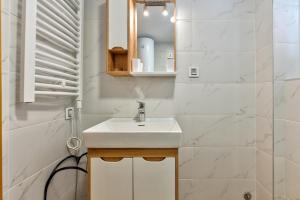 Un baño blanco con lavabo y espejo. en Tijana, en Zlatibor 30 fotos más