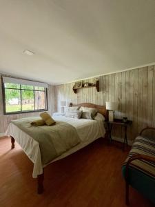 a bedroom with a large bed and a window at Las brujitas casa de campo in Loncopangue