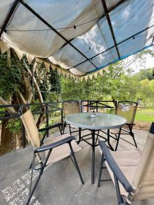 a patio with a table and chairs under a canopy at Las brujitas casa de campo in Loncopangue