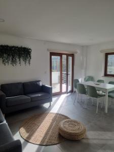 a living room with a couch and a table at Hortelã da Ribeira - Serra da Estrela in Cortes do Meio