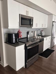 a kitchen with white cabinets and a black stove top oven at The Best Spot in Ottawa