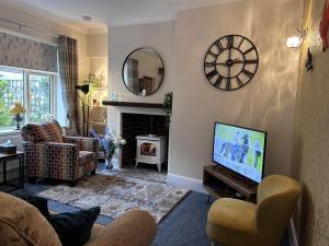 a living room with a television and a fireplace at Beautiful 2-Bed Cottage in Heysham Village in Heysham