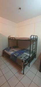 a bunk bed in a room with a tile floor at Hotel Allan Veintiocho Puntarenas in Puntarenas
