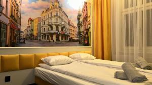 2 camas en una habitación con una foto de la ciudad en Quick Trip Apartments Toruń, en Toruń