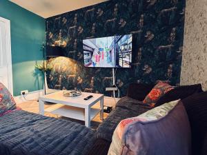 a living room with a couch and a tv at Brighton Beach House in Brighton & Hove