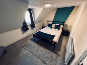ein Schlafzimmer mit einem Bett mit einer grünen Wand in der Unterkunft Brighton Beach House in Brighton & Hove